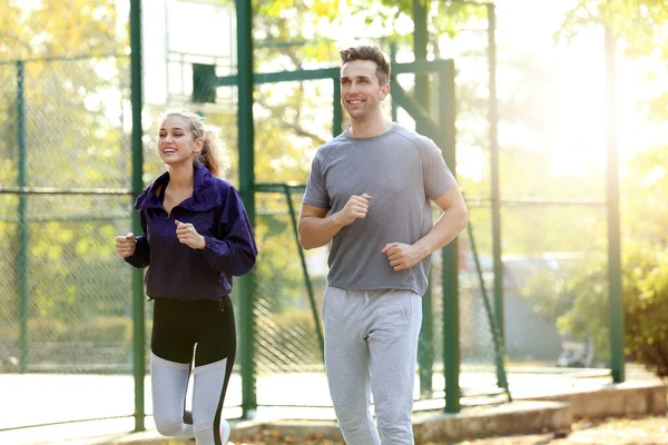 Deportiva joven pareja corriendo en parque — Foto de Stock