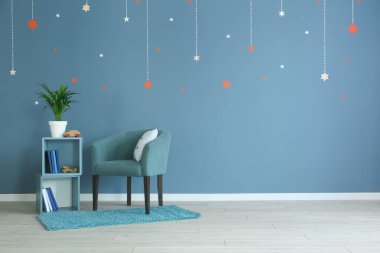 Renk duvarının yanında raf ünitesi ve koltuk