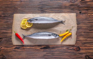 Tahta masada çiğ uskumru balıklı parşömen.