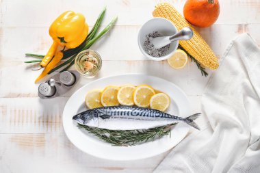 Çiğ uskumru balığı, limon ve biberiye ile ahşap masa.