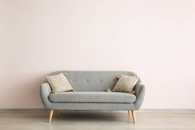 Işık duvarının yanındaki modern kanepe.