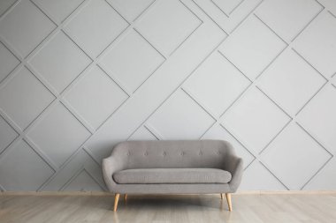 Işık duvarının yanındaki modern kanepe.