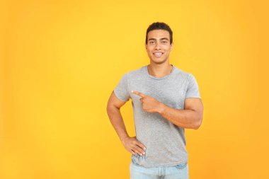 Yakışıklı Afrikalı-Amerikalı adam renk arka plan üzerinde bir şey işaret