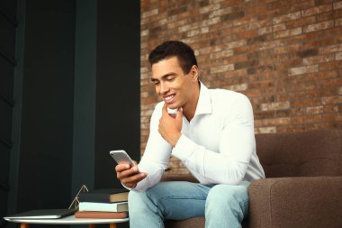 Evde cep telefonu ile Genç Afrikalı-Amerikalı adam