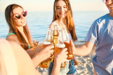 Arkadaşlar deniz plajında bira içiyor