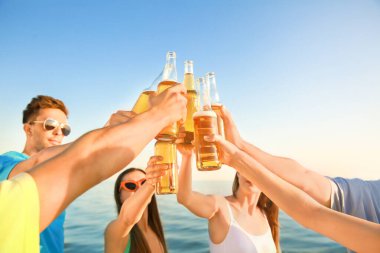 Arkadaşlar deniz plajında bira içiyor