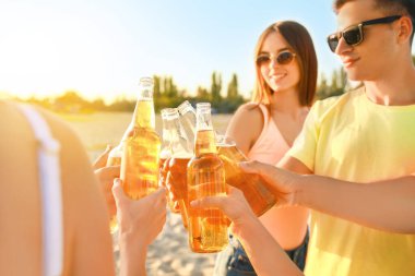Arkadaşlar deniz plajında bira içiyor