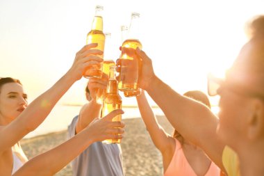 Arkadaşlar deniz plajında bira içiyor