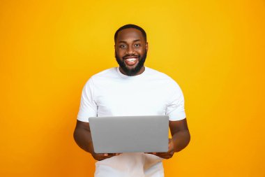 Renkli dizüstü bilgisayarı olan yakışıklı bir Afro-Amerikalı.