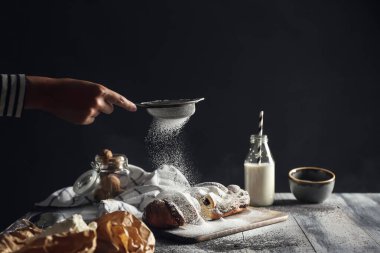 Bir kadın masaya şeker tozu serpiyor.