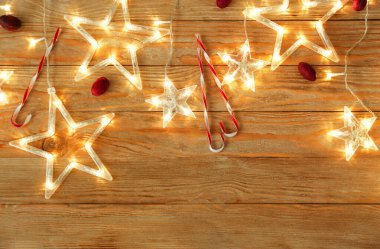 Ahşap arka planda Noel dekoru olan güzel, parıldayan bir çelenk.