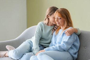 mutlu anne ile evde bir kanepede oturan kız