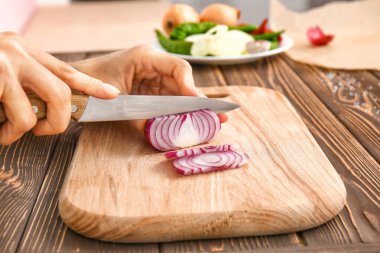 Mutfakta soğan doğrayan kadın, yakın plan.