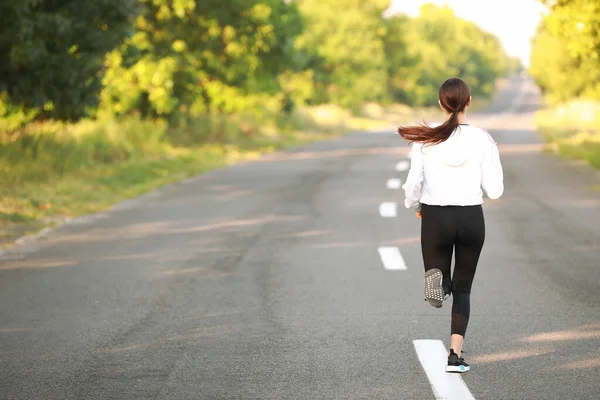 Sporty young woman running outdoors — Stock Photo, Image