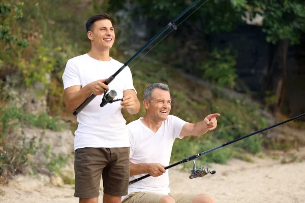 Joven y su padre pescando en el río — Foto de Stock