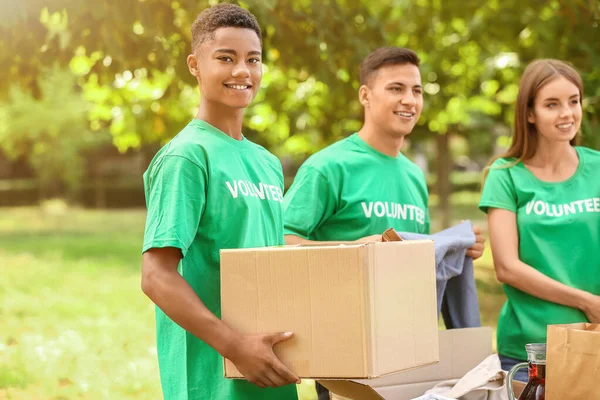 Young volunteers with donation for poor people outdoors — Stock Photo, Image