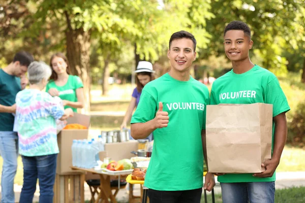 Jóvenes voluntarios con donación para pobres al aire libre — Foto de Stock
