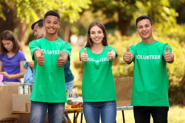 Młodzi wolontariusze pokazujący gest kciuka na świeżym powietrzu — Zdjęcie stockowe