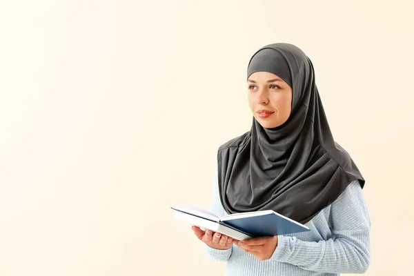 Porträt einer muslimischen Frau mit Büchern auf hellem Hintergrund — Stockfoto