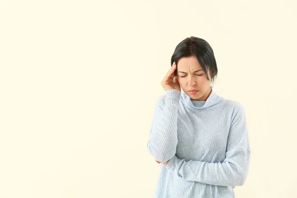 Porträtt av kvinna som lider av huvudvärk på ljus bakgrund — Stockfoto