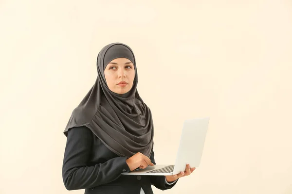 Porträt einer muslimischen Frau mit Laptop auf hellem Hintergrund — Stockfoto