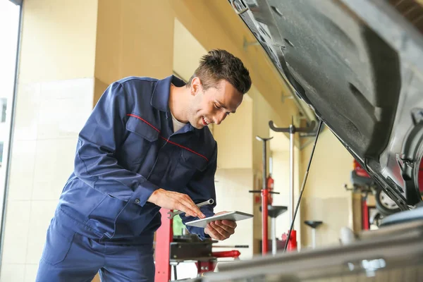 Carro mecânico masculino reparando no centro de serviço — Fotografia de Stock