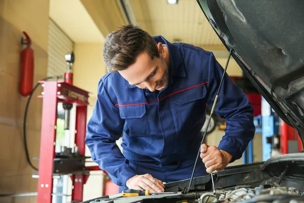 Mężczyzna mechanik naprawy samochodu w centrum serwisowym — Zdjęcie stockowe