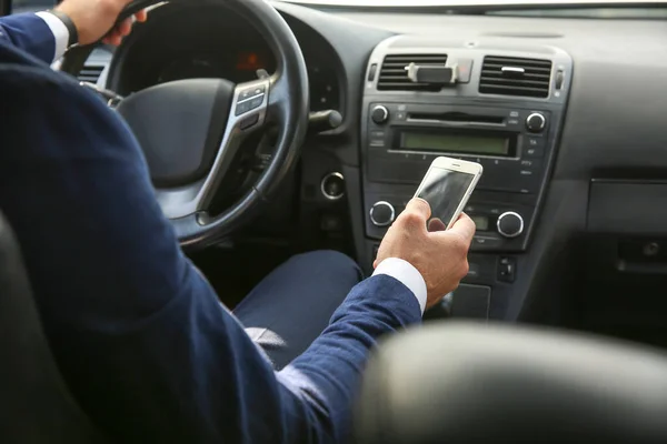 Uomo d'affari di successo utilizzando il telefono cellulare durante la guida di auto moderne — Foto Stock