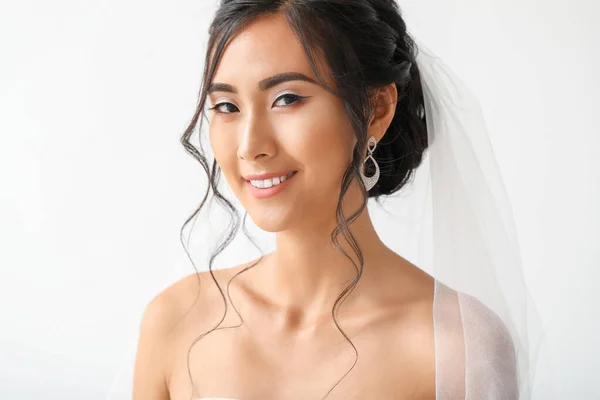 Beautiful young Asian bride on light background — Stock Photo, Image