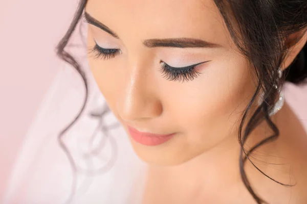 Beautiful young Asian bride on color background, closeup — Stock Photo, Image