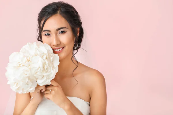 Beautiful young Asian bride on color background — Stock Photo, Image