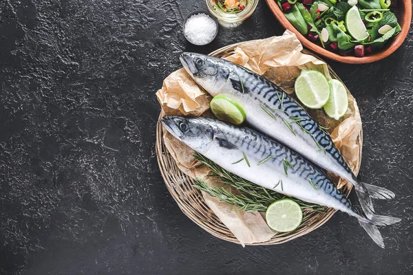 Talíř se syrovou makrelovou rybou a zeleninovým salátem na tmavém pozadí — Stock fotografie