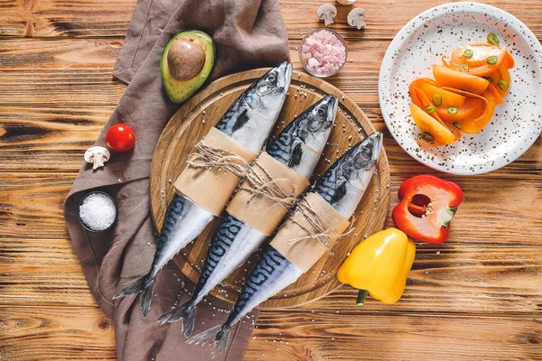 Plateau avec poisson et légumes crus de maquereau sur fond en bois — Photo