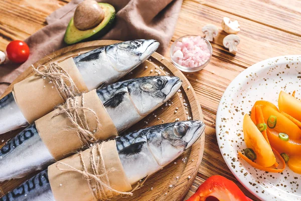 Deska se syrovou makrelou ryby a zeleniny na dřevěném pozadí — Stock fotografie