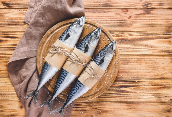 Board with raw mackerel fish on wooden background — Stock Photo, Image