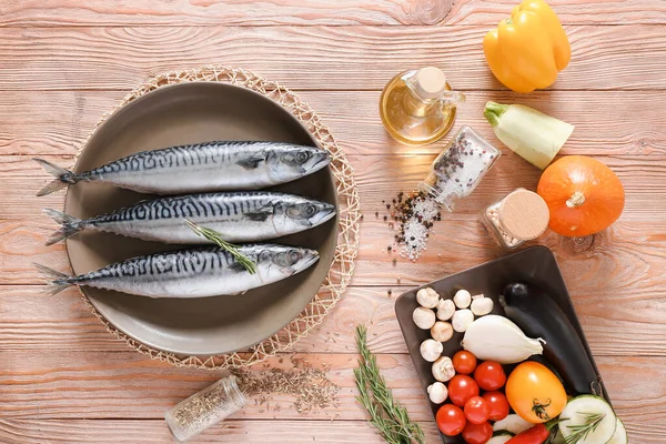 Talíř se syrovou makrelovou rybkou a zeleninou na dřevěném stole — Stock fotografie