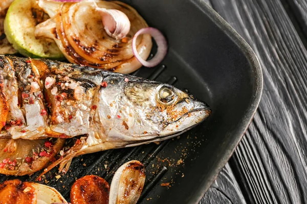 Grill pan with prepared mackerel fish and vegetables on dark table, closeup — Stock Photo, Image