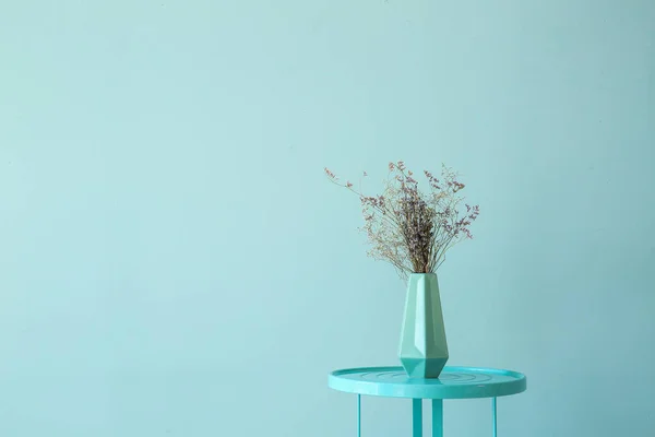 Современный стол с вазой на цветном фоне — стоковое фото