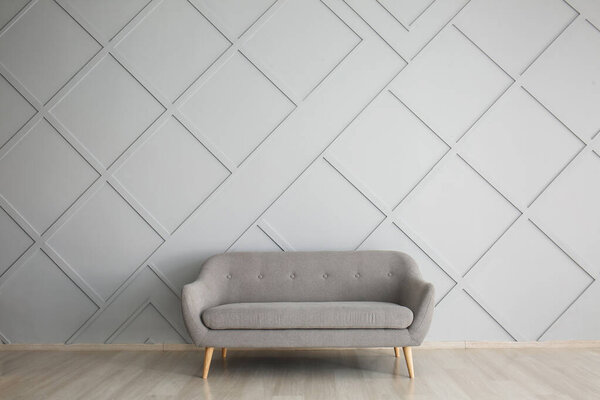 Modern sofa near light wall