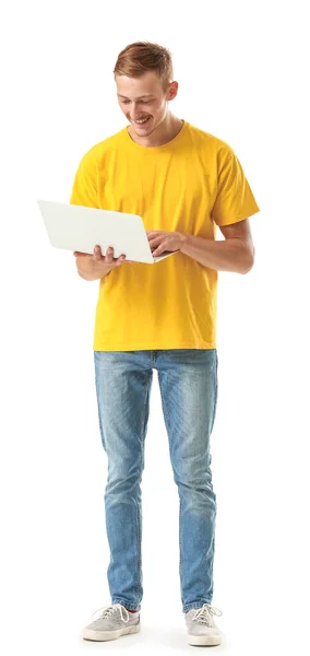 Hombre joven en elegante camiseta y con portátil sobre fondo blanco — Foto de Stock
