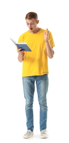 Homem surpreso em elegante t-shirt e com livro sobre fundo branco — Fotografia de Stock