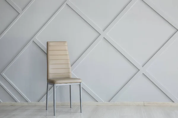 Stylish chair near grey wall in room — Stock Photo, Image