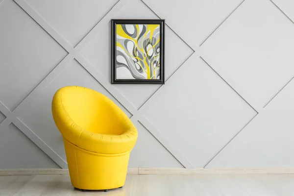 Stylish armchair with picture on grey wall in room — Stock Photo, Image