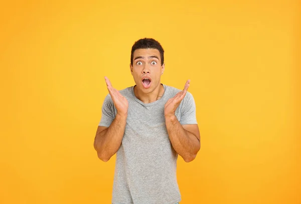 Shocked African-American man on color background — Stock Photo, Image