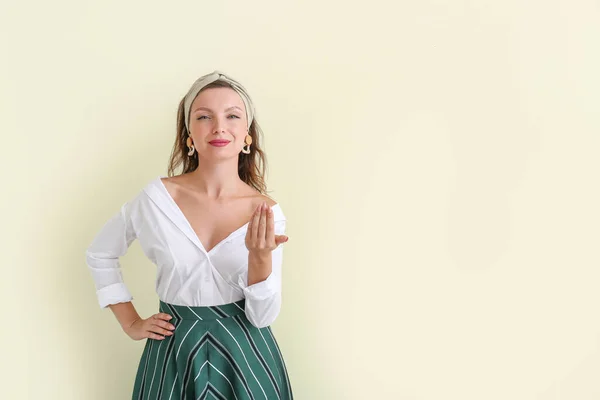 Beautiful young woman inviting viewer on light background — Stock Photo, Image