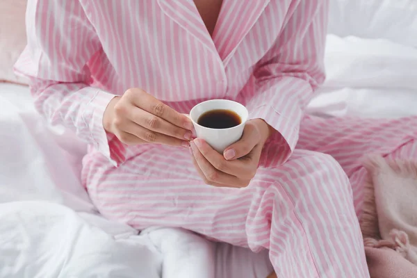 Yatakta sıcak kahve içen genç kadın, yakın plan. — Stok fotoğraf