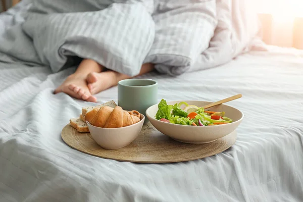 Mujer con sabroso desayuno acostado en la cama — Foto de Stock