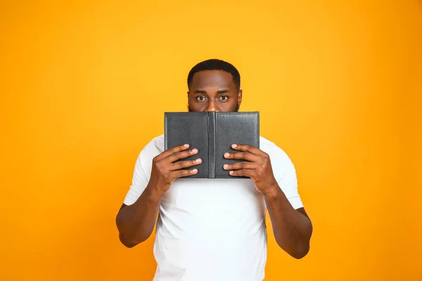 Bel homme afro-américain avec livre sur fond de couleur — Photo