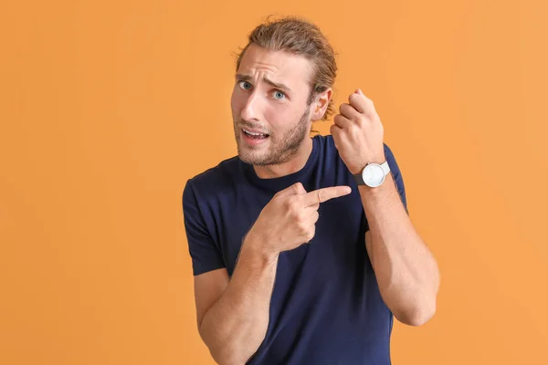 Stressed man with watch on color background — Stock Photo, Image