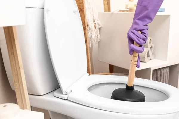 Man using plunger to unclog a toilet bowl — Stock Photo, Image